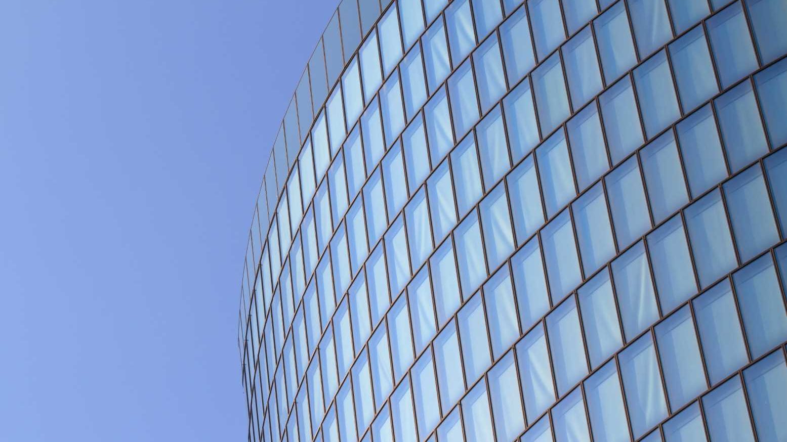 Modern,Glas,Facade,Of,Office,Tower,In,Front,Of,Blue